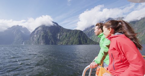 Cruise ship tourists on boat tour in Milford Sound, Fiordland National Park, New Zealand. Happy couple on sightseeing travel on New Zealand South Island. SLOW MOTION Cinema Camera.