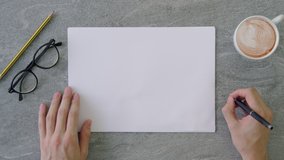 Top view shot of a man pretending to write with his pen on a stack of a4 piece of paper placed on a marble table top surface with coffee, reading glasses and office utensils. - Powered by Shutterstock - Get 15% off with code: PIKWIZARD15