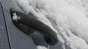 Snowing over a gray car handle