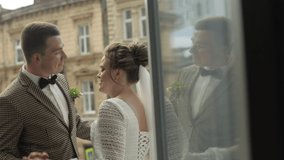Newlyweds. Lovely young caucasian bride and groom dancing, kiss on balcony. Happy wedding couple family. Man and woman in love. Bride in gorgeous wedding dress. Bridegroom in jacket. Slow motion