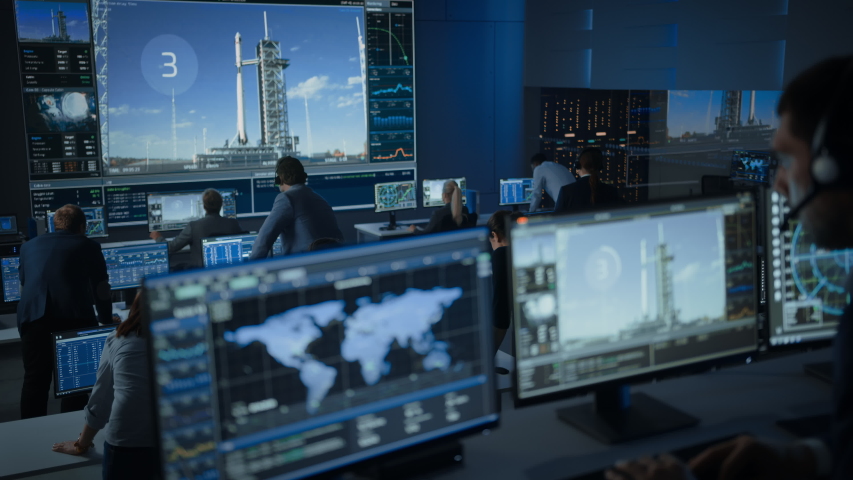 Group of People in Mission Control Center Witness Successful Space Rocket Launch. Flight Control Employees Sit in Front Computer Displays and Monitor the Crewed Mission. Team Stand Up and Clap Hands. | Shutterstock HD Video #1056388178