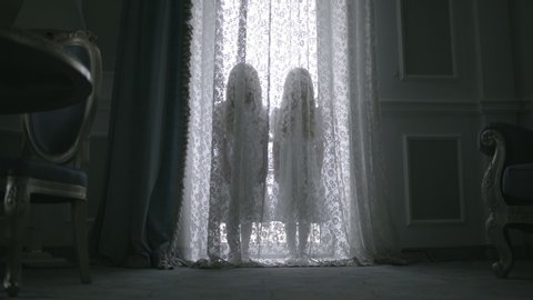 Nightmarish silhouettes of two little girls hiding behind curtains haunted house