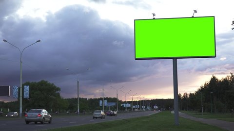 Mock up concept. Green screen billboard on the the highway against the background of the evening sky.