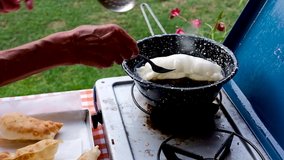 Emilian cook dips in a frying pan full of seed oil the dough for the fried dumplings. Procedure for the preparation of fried gnocchi, an irresistible homemade Italian specialty