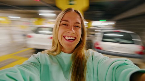 User generated content, couple pov girlfriend spinning with boyfriend in shopping mall parking lot. portrait of happy woman on wide angle action camera laughing and smiling, have great time in love