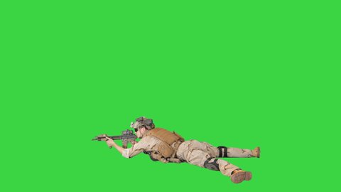Soldier taking lying position and aiming at a target from automatic weapon on a Green Screen, Chroma Key.