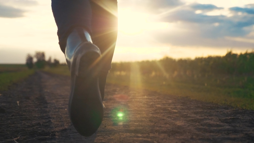 agriculture. girl farmer in rubber boots walks along a country road near a green field of wheat grass. farmer worker goes home after harvesting end of the working day feet in rubber boots agriculture Royalty-Free Stock Footage #1056415271