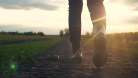 agriculture. girl farmer in rubber boots walks along a country road near a green field of wheat grass. farmer worker goes home after harvesting end of the working day feet in rubber boots agriculture - Powered by Shutterstock - Get 15% off with code: PIKWIZARD15