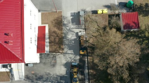 Three street sweepers cleaning a parking lot. Aerial top-down view