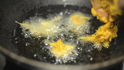 Indian kanda bhaji frying in hot oil, India street food.