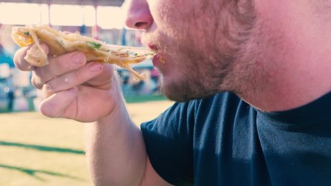 Person Eating a Very Cheesy Quesadilla at a Food Festival with some String Cheese Stretching in Slow Motion.