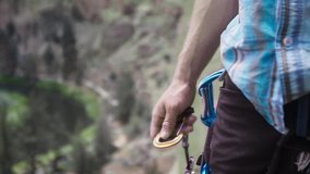 Close up shot of young climber attaching carabiner to harness in Smith Rock