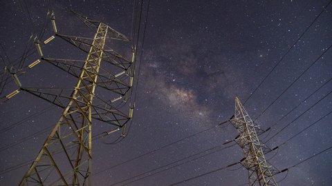 High voltage electric tower on milky way sky background, transmission power line and a Parts of electrical equipment and high voltage power line insulators at night 