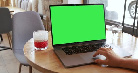 Woman hands typing on Macbook Pro 16 2019 keyboard in coffeeshop. Unrecognisable person working on laptop notebook green screen chromakey monitor. Mock-up. Pre keyed chroma key. 2020 - USA, California