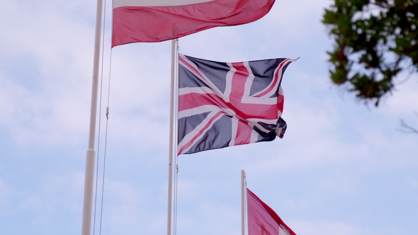 United Kingdom flag at slow motion. England symbol. English patriotism. Union Jack. Great Britain, Northern Ireland, Scotland, Wales. Red cross, white and blue. Royalty-Free Stock Footage #1056440138