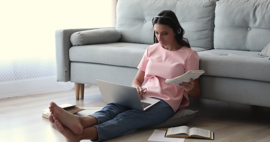 Self-education work on project using modern tech internet connection web library concept. Indian woman learn language, prepare for college exam sit on floor in living room with underfloor heat concept Royalty-Free Stock Footage #1056440231
