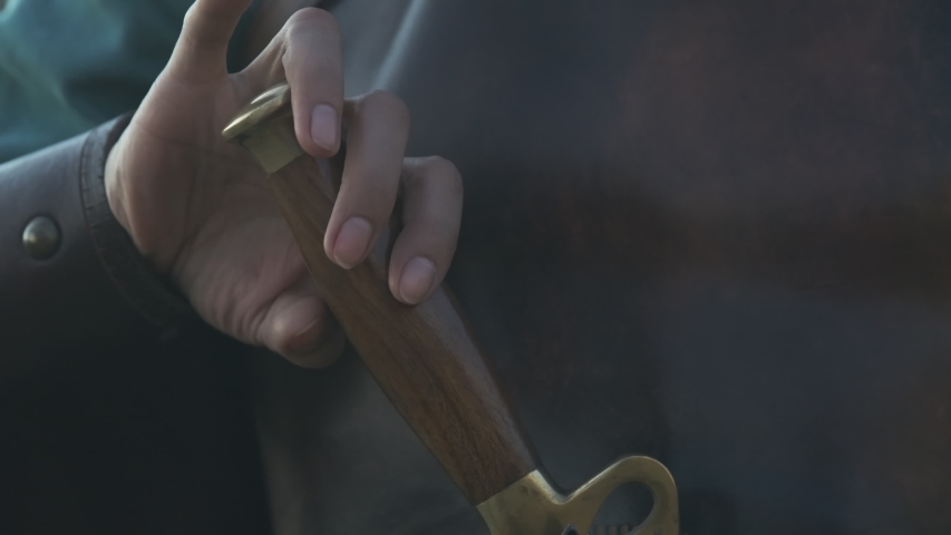 Warrior woman's hand takes a sword out of the sheath, close-up
 | Shutterstock HD Video #1056440672