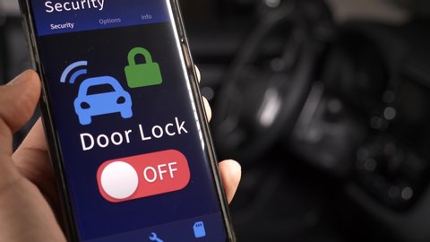 Locking and unlocking the doors of a car using a mobile phone application. Security smartphone app for the car concept.