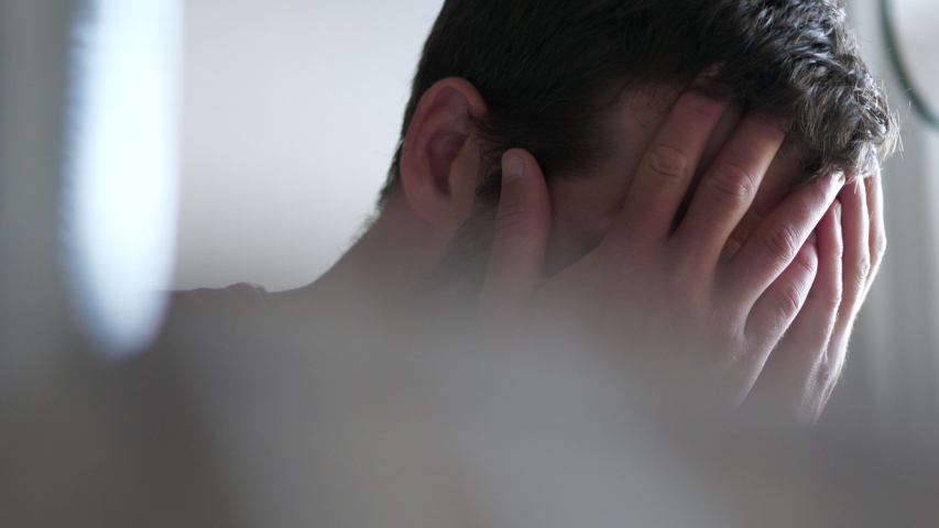 Depressed man covers face with hands, dolly shot Royalty-Free Stock Footage #1056443093