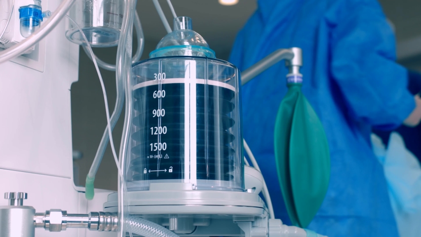 Close-up of a ventilator during an operation, 4k shot. The movement is remembered by artificial lung ventilation, amid a ward with a patient and doctors. Pneumonia and tuberculosis, Covid 19 Royalty-Free Stock Footage #1056444596