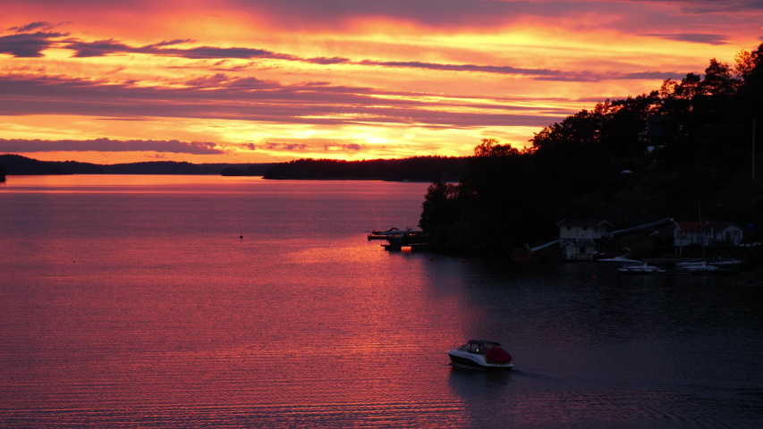Motor boat at sunset over Scandinavian lake