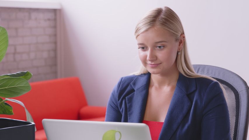 A deaf caucasian woman is making a video call and signing to relatives and friends with a laptop at home. Sign language. Technology, modern generation, family, connection, authenticity. - slow motion Royalty-Free Stock Footage #1056448028