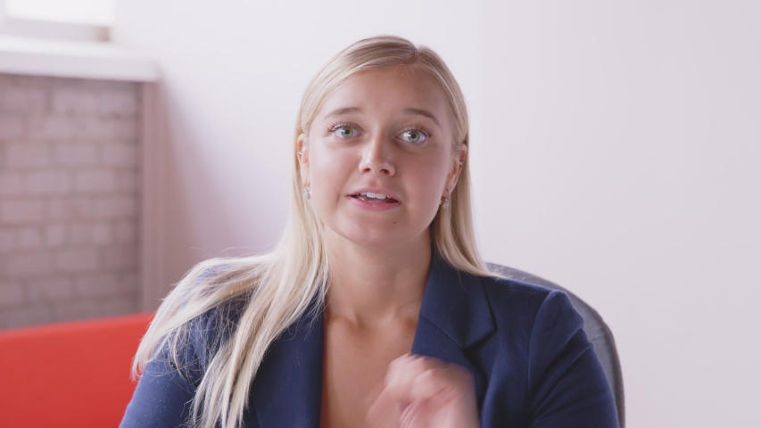 Camera POV of a young caucasian woman having a sign language conversation online in a remote video conference call, signing and waving hello Royalty-Free Stock Footage #1056448190