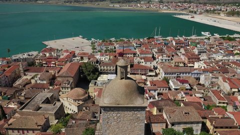 Aerial drone flight above old clock tower in historic and picturesque seaside old town of Nafplio, Argolida, Peloponnese, Greece