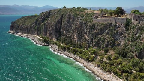 Aerial drone video of famous castle and beach of Arvanitia in the slopes of Acronafplia, Nafplio, Argolida, Peloponnese, Greece