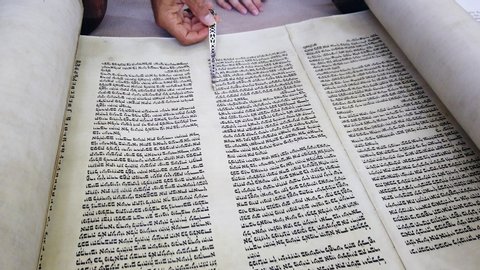 Jerusalems ,ISRAEL - July 6,2020: Jewish Rabbi read Torah scroll with TORA reading hand.