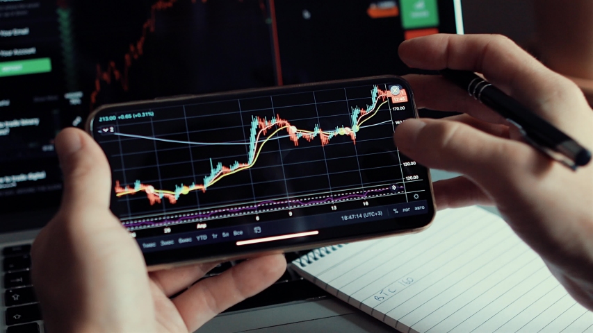 investment stockbroker stock market analysis data graph with price rates. Stock market trader analyzing bitcoin price trend. Investment broker trading bitcoin crypto currency using phone and laptop Royalty-Free Stock Footage #1056469511