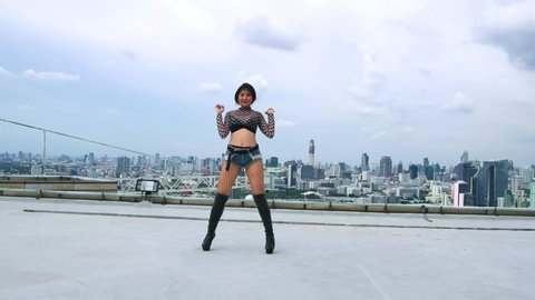 Beautiful youth young woman professional performer exercise fun smiling dancing outdoor on the rooftop downtown city view building background. 