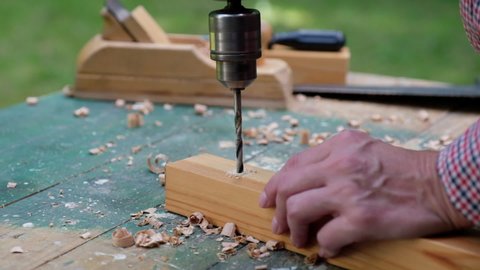 Craftswoman drilling wooden plank, close-up view. Woodworking, using carpentry tool concept.