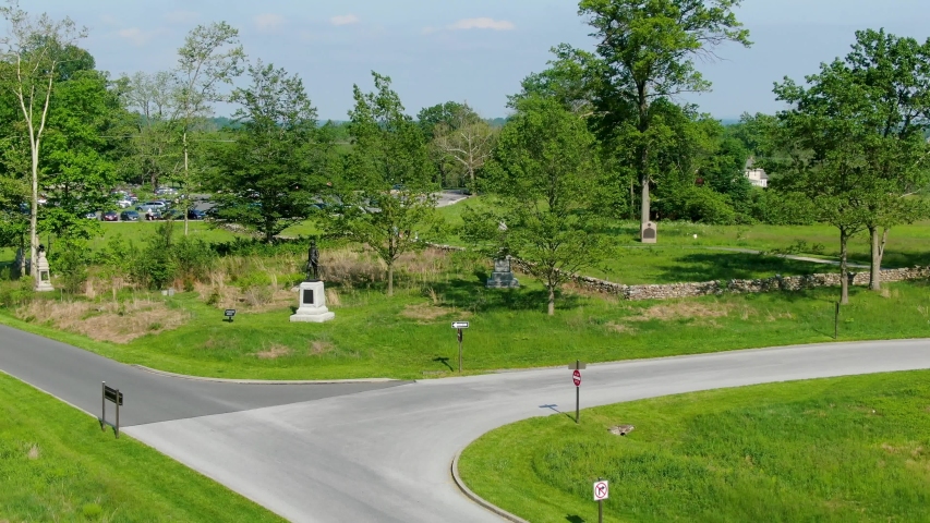 Rising aerial reveals  Civil War Battlefield in Gettysburg, PA, tourists at Visitors Center parking