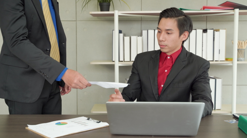 man get fired, An Asian office worker man has received a letter to dismiss him. He is stressed and shocked because he has not been prepared for the job due to lack of income. Royalty-Free Stock Footage #1056479246