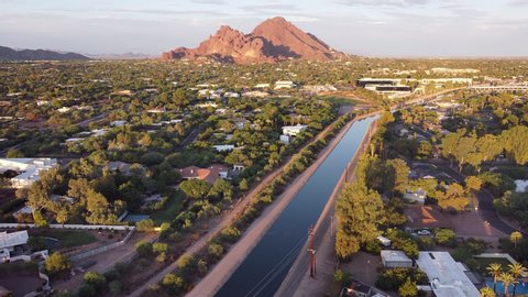 Aerial footage of Phoenix, Arizona with Camelback Mountain glowing red in the evening sun.   