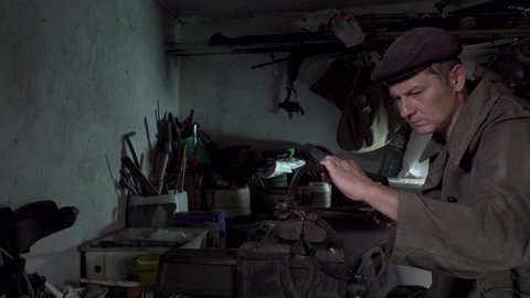 A man works in an old home workshop. Artisanal production. 4K