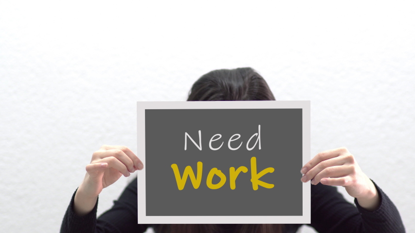Conceptual message "Need Work" on canvas frame label hold by beautiful girl smiling at camera