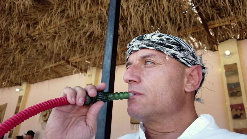 Man Smoking Shisha At visit of Bedouine village in Egypt