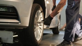 Car mechanic replacing a car tire in garage workshop. Slow motion. Auto service - Powered by Shutterstock - Get 15% off with code: PIKWIZARD15
