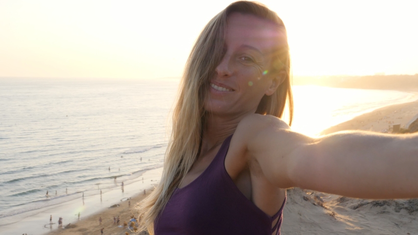 SLOW MOTION: Selfie of young woman by the beach at sunrise  | Shutterstock HD Video #1056512141