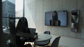 Women in masks making a long distance hiring video call in office 