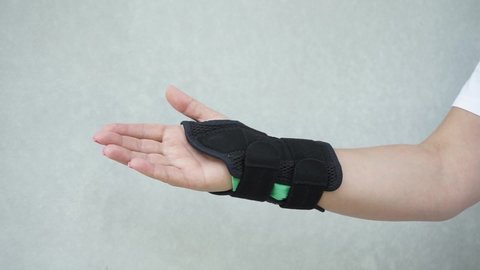 Woman take off the wrist brace for the treatment of carpal tunnel syndrome or median nerve compression, numbness hand