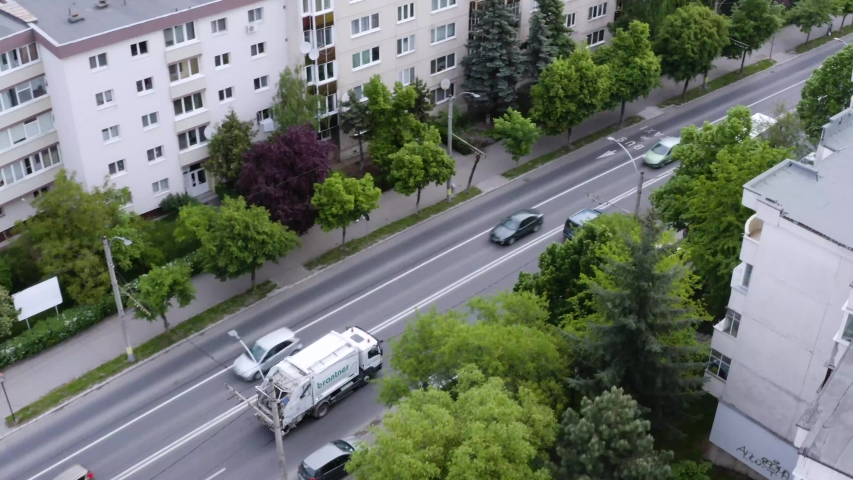 Aerial shot of the garbage truck driving through the city collecting trash. Stop pollution Royalty-Free Stock Footage #1056524702