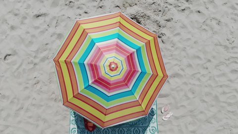 Top view on a sun lounger under an umbrella on the sandy beach. Concept of summer vacation