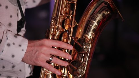 Saxophonist playing at a live concert, fingers closeup