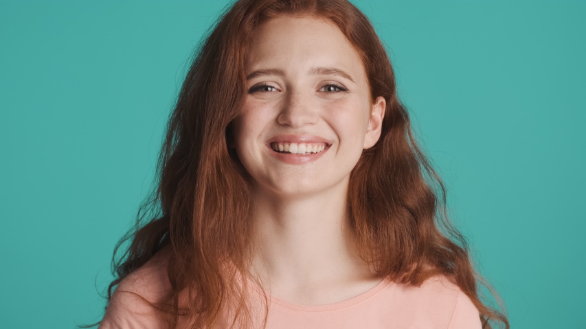 Portrait of pretty redhead woman happily smiling on camera over colorful background. Happy expression | Shutterstock HD Video #1056532208