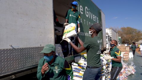 AFRICA,SOUTH AFRICA,CIRCA 2020. Volunteers from the NGO, The Gift of the Givers,taking food parcels out of trucks to distribute to the poor and hungry during the Covid-19 pandemic