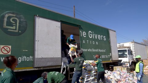 AFRICA,SOUTH AFRICA,CIRCA 2020. Volunteers from the NGO, The Gift of the Givers,taking food parcels out of trucks to distribute to the poor and hungry during the Covid-19 pandemic