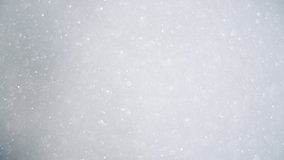 Beautiful snow flakes swirls in air in slow motion, close up of falling snow on white background - Powered by Shutterstock - Get 15% off with code: PIKWIZARD15